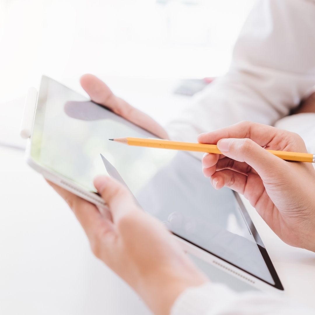 Two people working on a resume on a tablet.