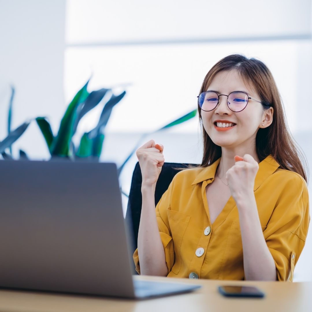 A woman looking confident while working at a laptop.