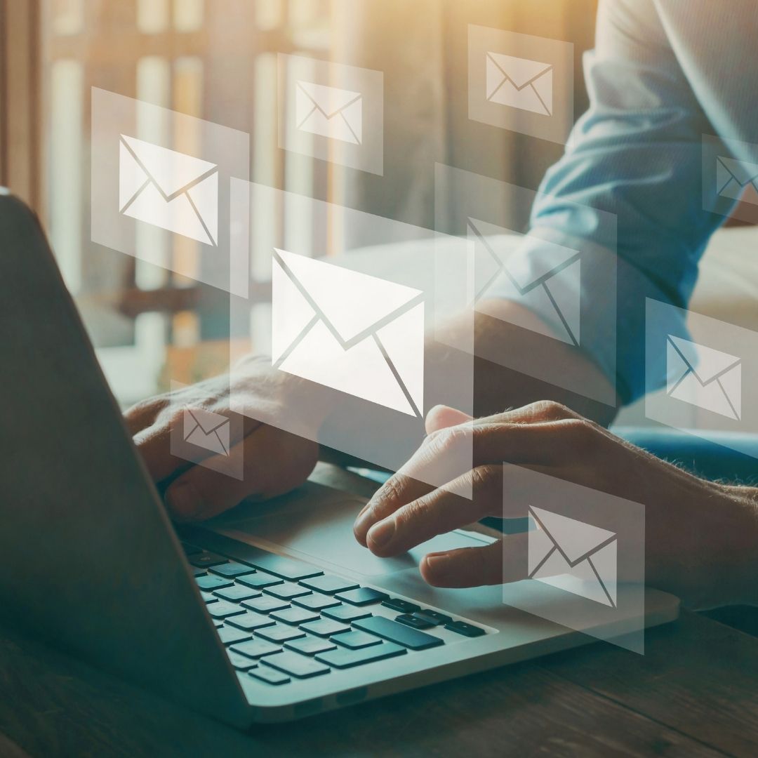 An image of an open laptop with an overlay of email symbols.