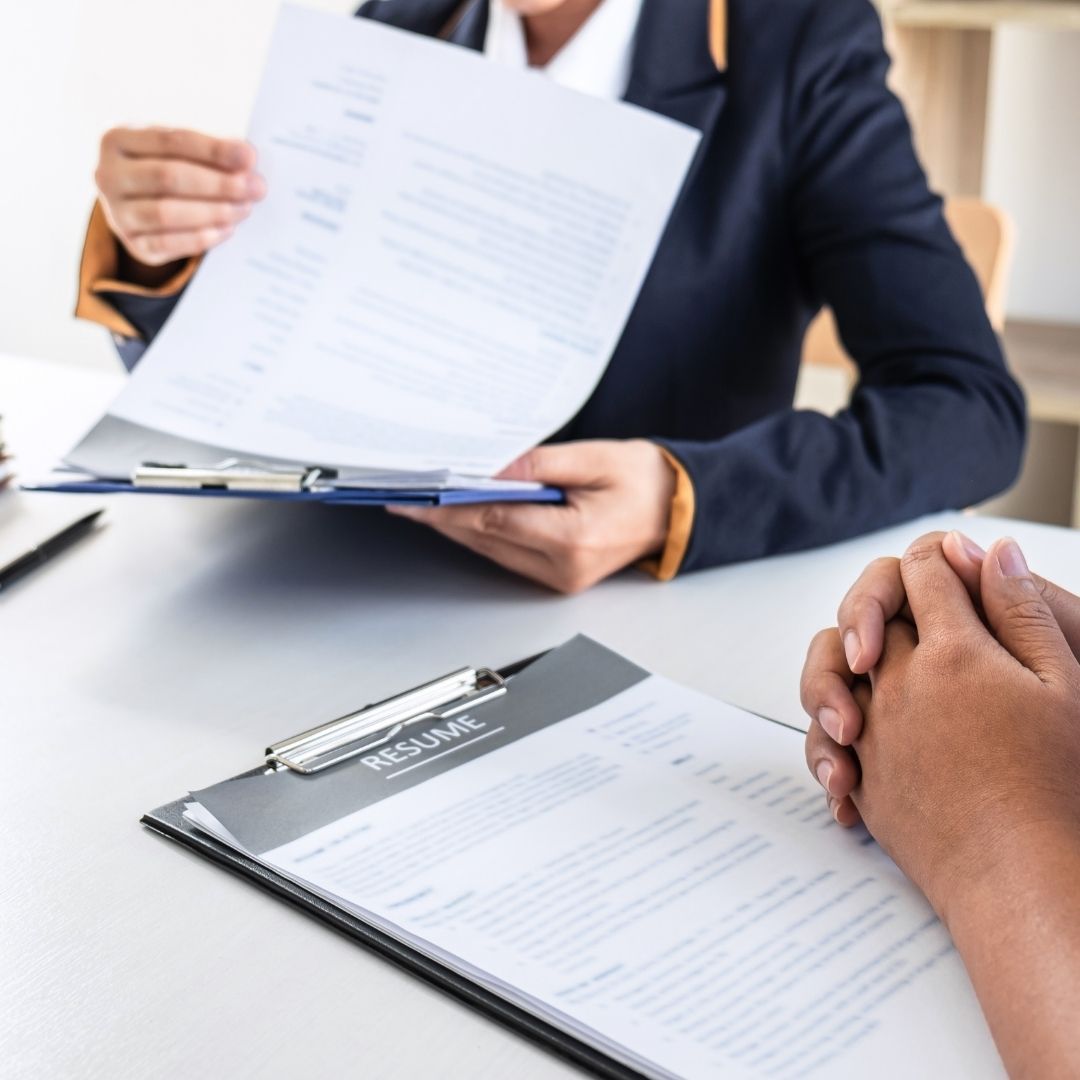 Two people looking at copies of a resume at a table.