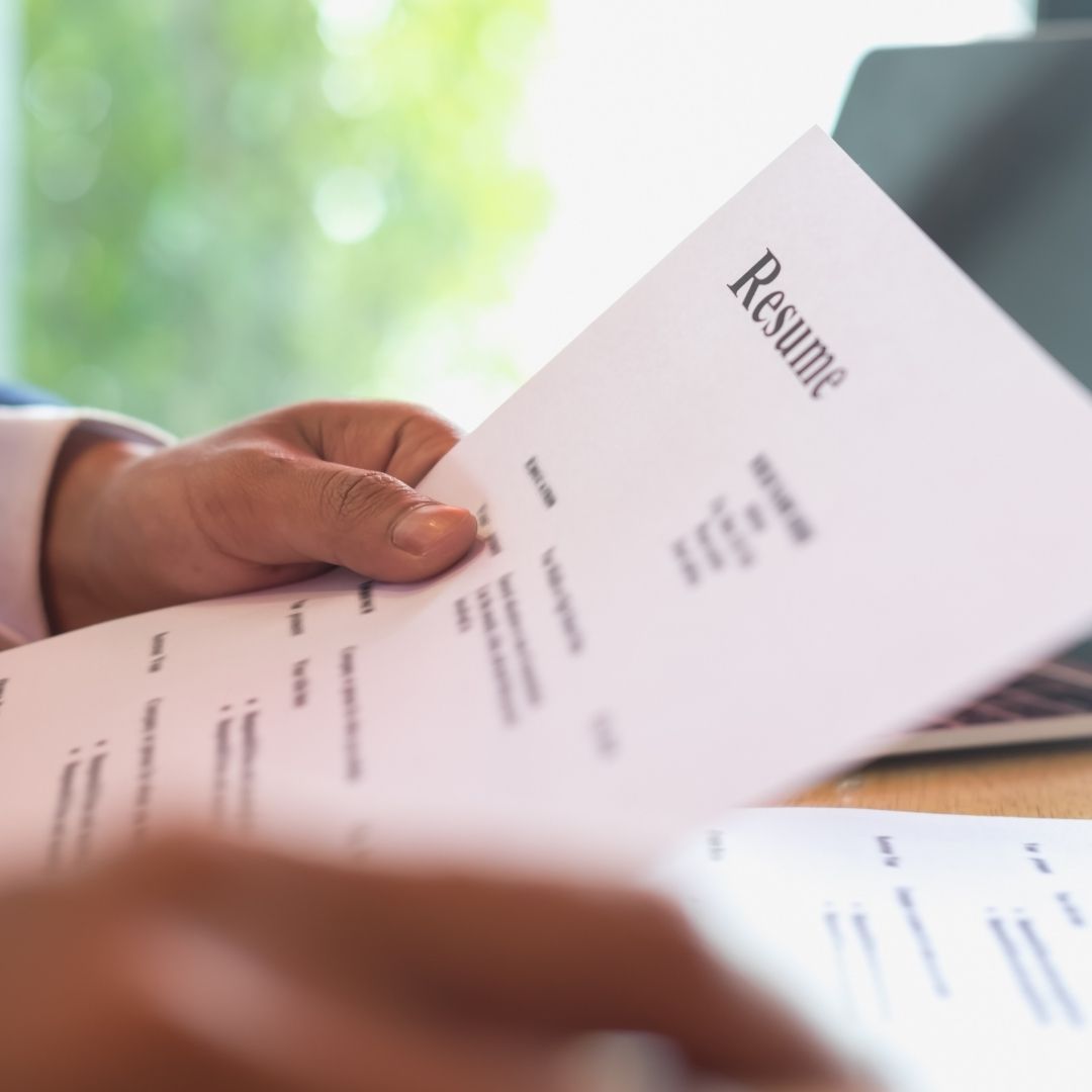 An image of someone holding a resume.